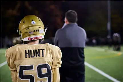 Jim Hunt talking with a young player wearing a Hunt number 59 jersey
