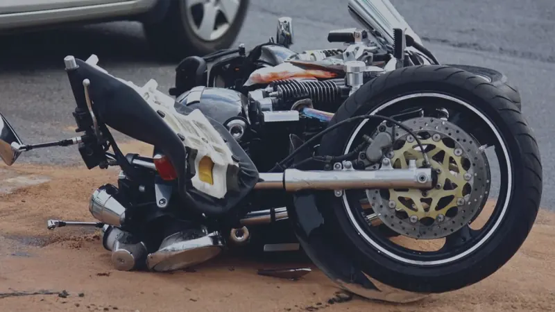 A motorcycle on its side on the road after a collision
