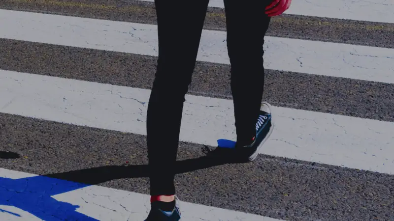 A pedestrian walking across a marked crosswalk